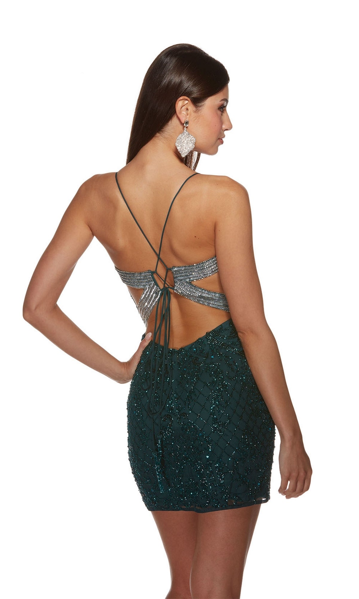 A woman wears the Alyce Open-Back Short Beaded Hoco Dress 4842, a dark green sequined party dress with crisscross straps and an open back, paired with large earrings, standing against a white background.